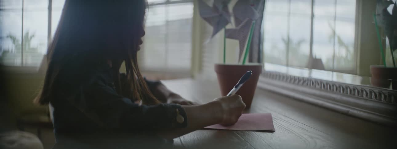 A child is writing with a pen