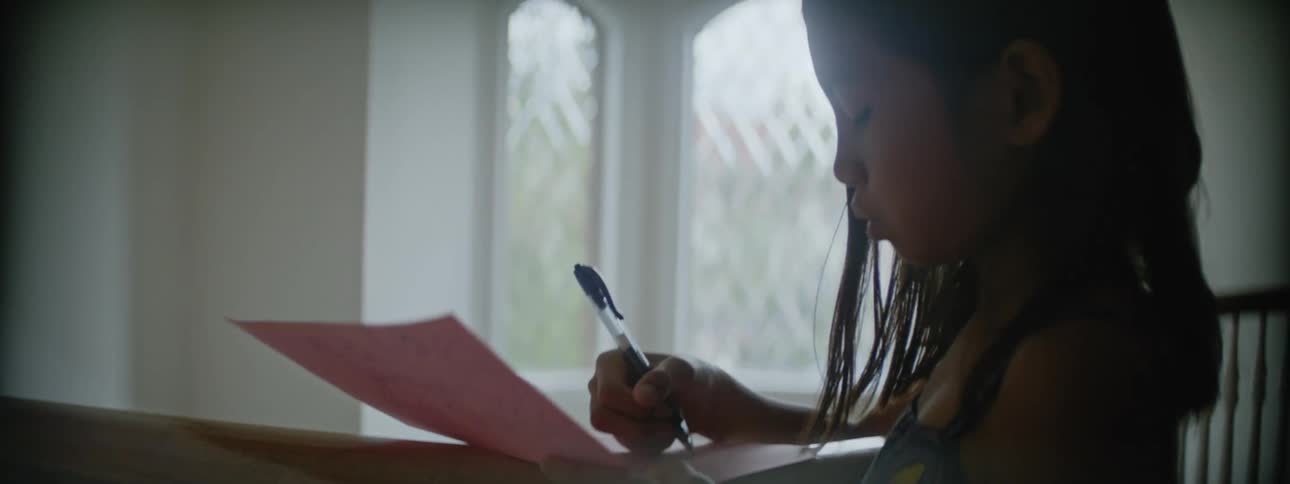 A girl writing on a piece of paper