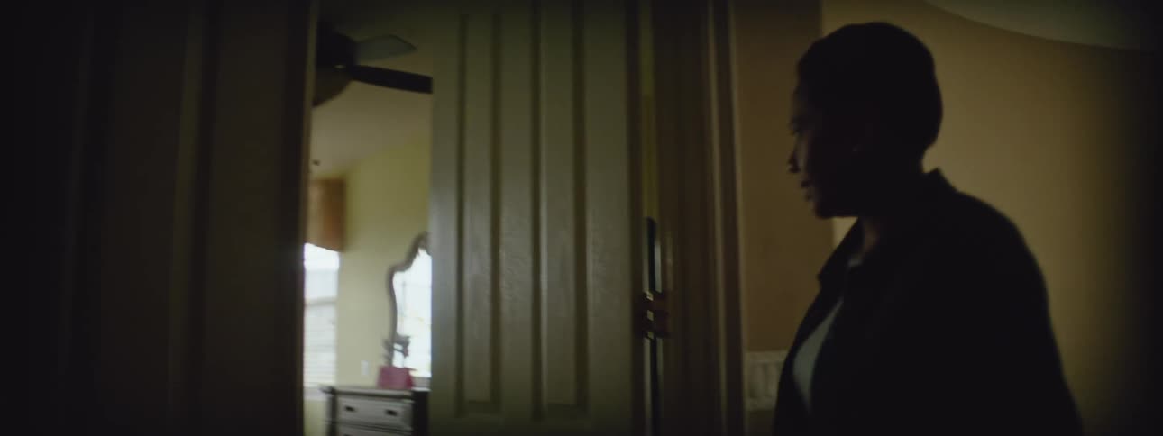 An older woman is walking up the stairs inside of her house
