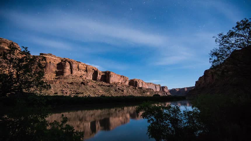 Time lapse of a river below some cliffs
