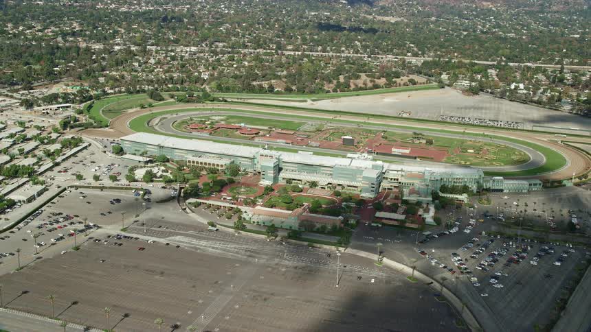 A stunning aerial view of Santa Anita Park horse racing track surrounded by partly cloudy skies in Arcadia California