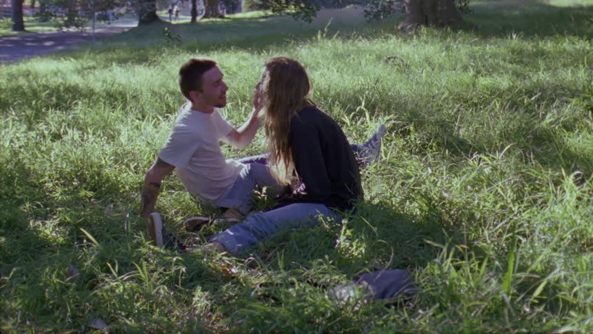 A couple kiss in the grass