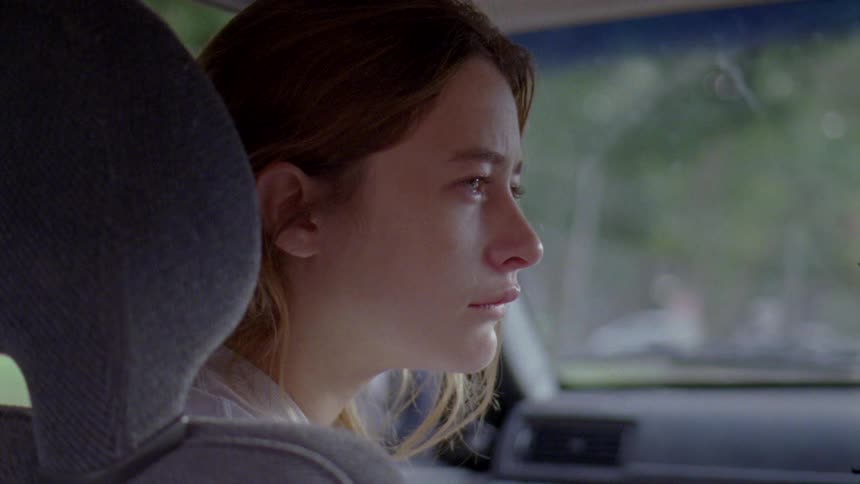 A woman is sad in the car