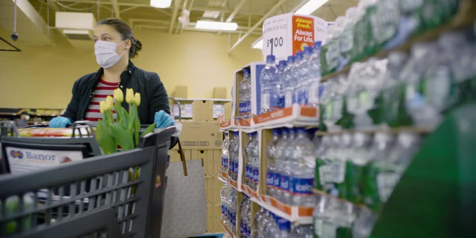 A woman puts an item in her shopping cart at a grocery store