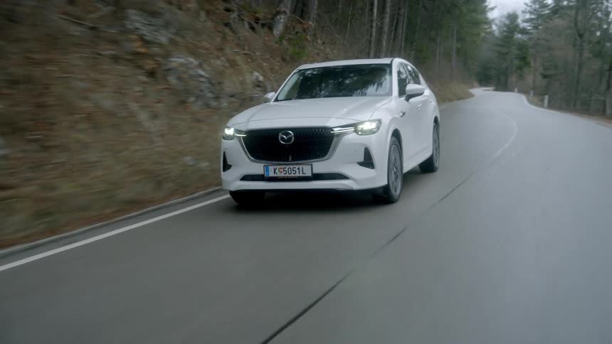 Car is driving on a road in a wooded rural area