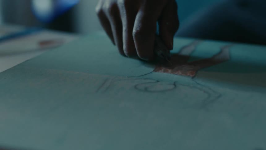 A person is doing artwork on the canvas
