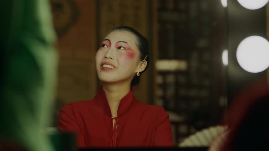 A young woman is indoors and is talking to someone else