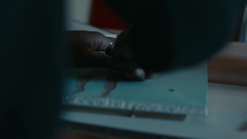 A person using a tool to carve out small shapes on a board