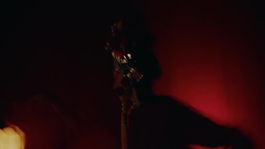 Stage lighting reveals woman standing on stage in chinese opera costume