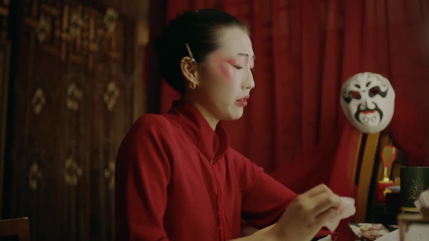 Actress sitting on a dressing room prepares for a chinese theatre performance talking to herself