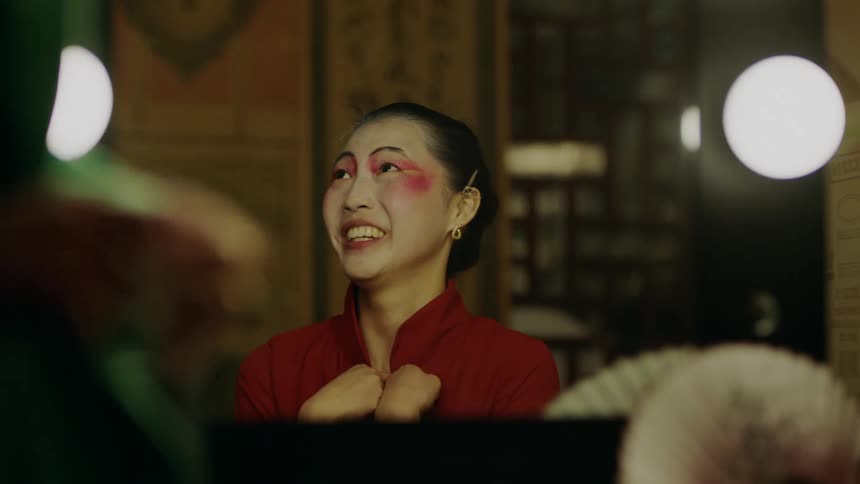 Close up of an actress in makeup sits on the changing room listening to someone