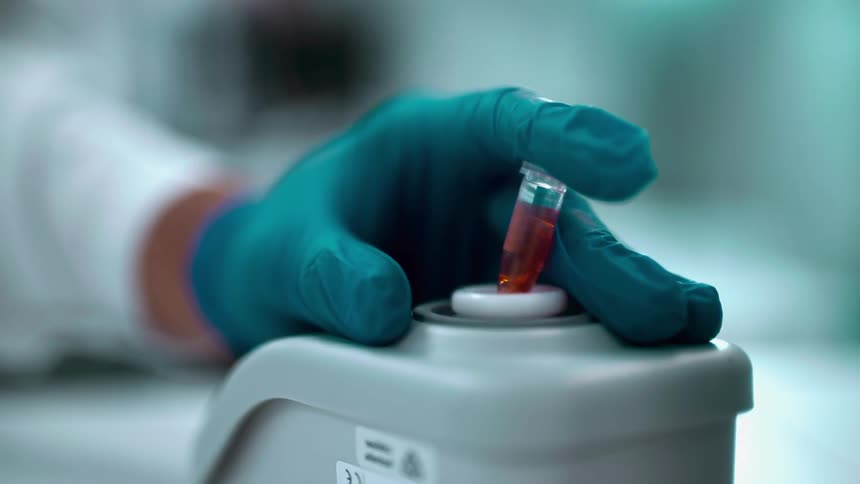 Close up of the hand of a laboratory worker using an automatic blood shaker machine