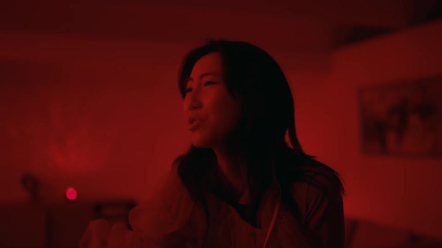 Young woman inside a room under red lights arguing with someone