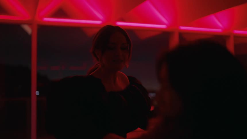 Two women standing in a kitchen talking when one woman starts to walk away and the second women aggressively tries to stop her