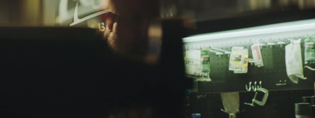 Close up of the face of a bearded man working on his workshop at daytime