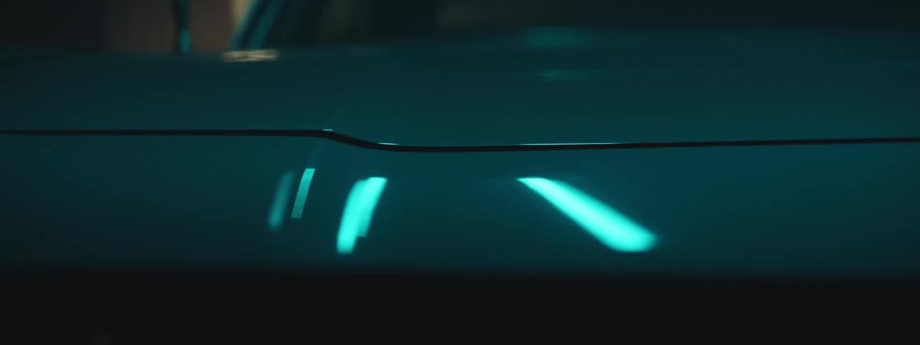 Close up of flashing lights alternatively reflecting over the shiny body of a luxury sports car
