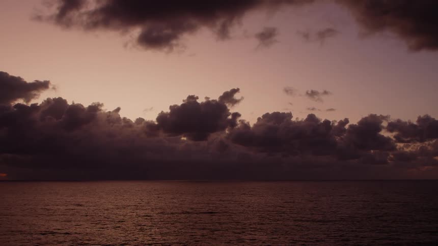 The sun is setting on the ocean