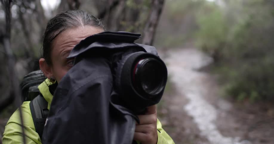 Woman raising her camera to her eye and aiming