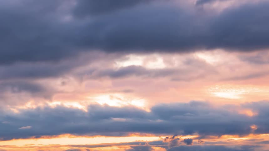 Thick clouds move across the sky and reflect sunlight as the colors change