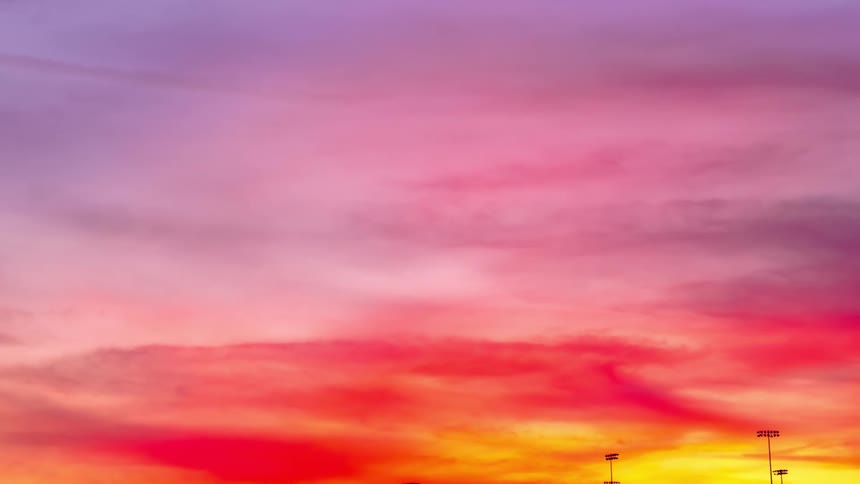 Clouds travel through the sky at sunset
