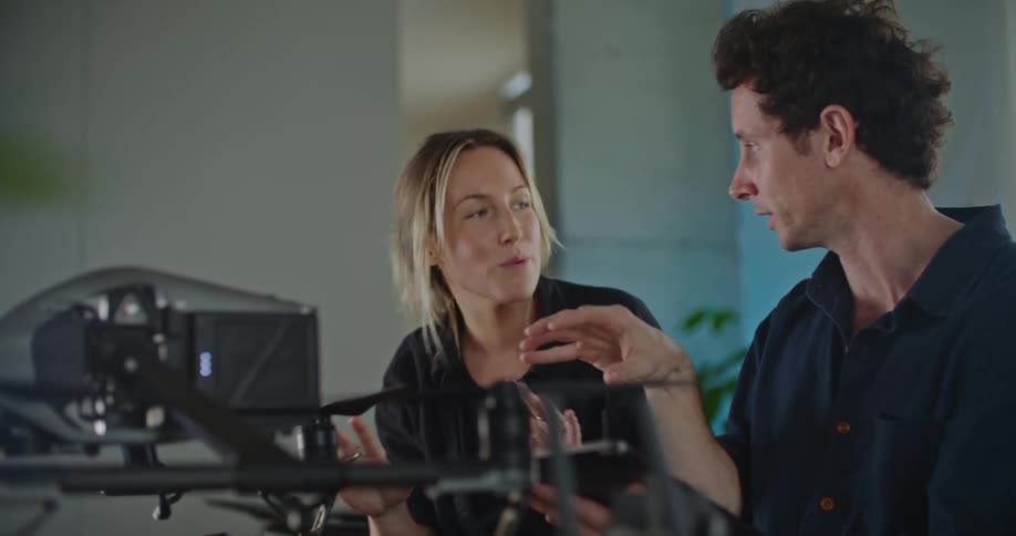 Young woman and man are indoors and are talking to each other