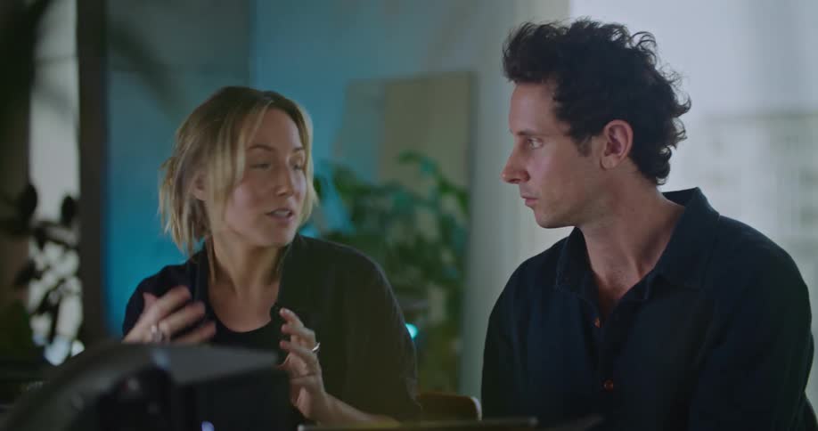 Coworkers discussdevice while consulting tablet