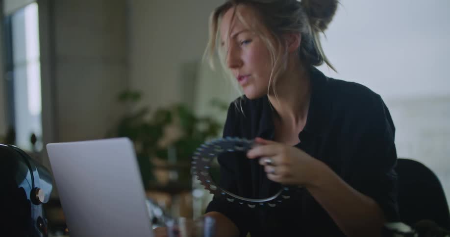 A young woman is indoors and using her laptop