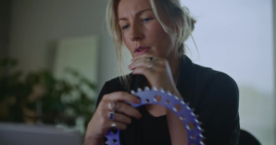 A woman is standing indoors and holding an object