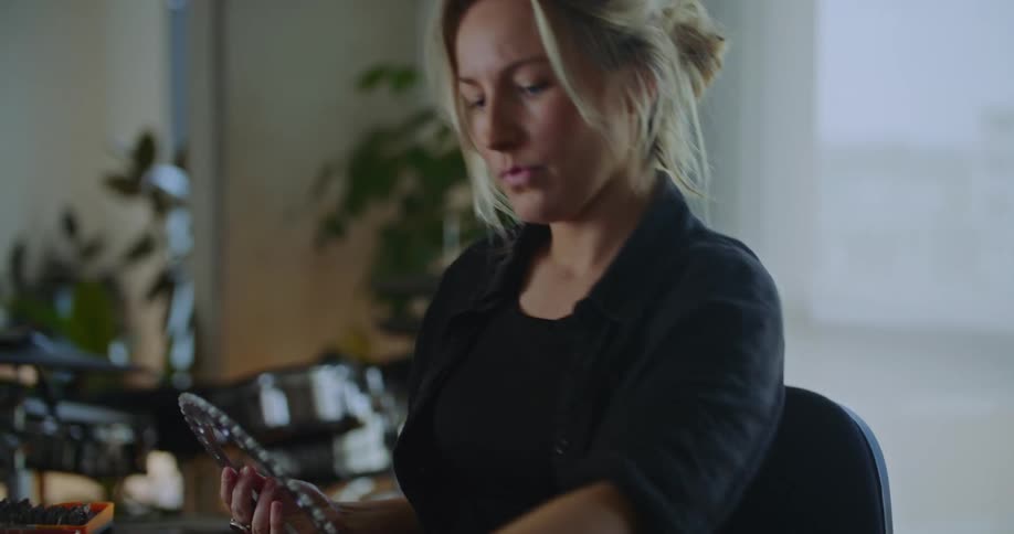 Woman sitting in office at desk examines gears