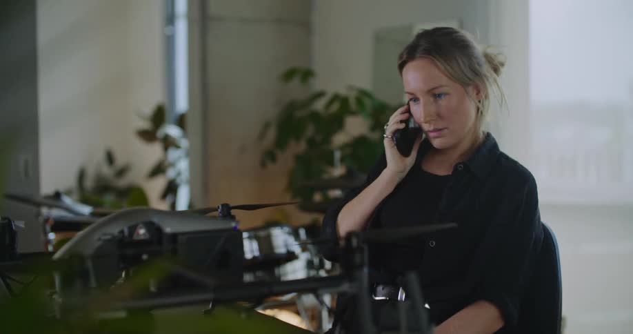 A young woman is inside of her home and is talking on the phone
