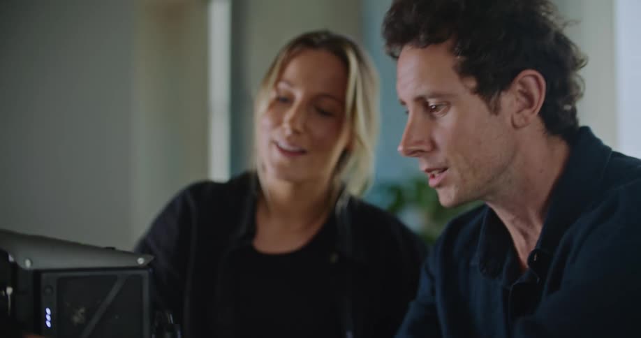 A man and woman chat while fixing a computer