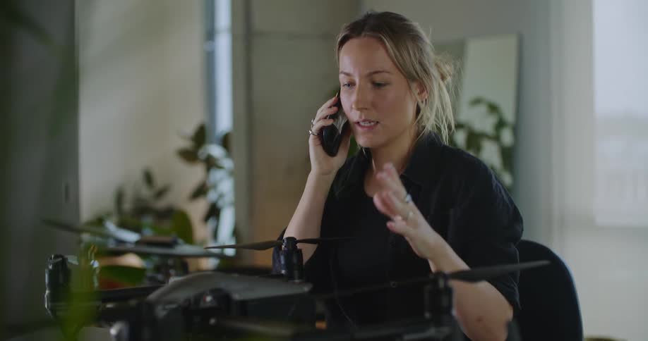 A woman is smiling and talking on the phone