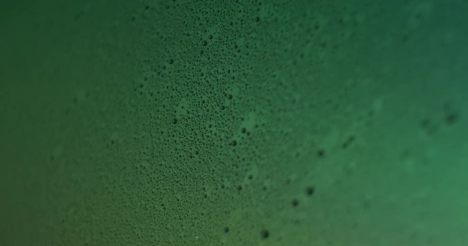 Textured spots appear across the surface lit by changing pastel colored lights