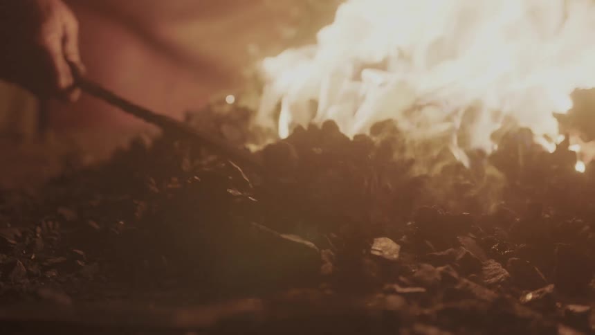 A fire is stirred with a poker