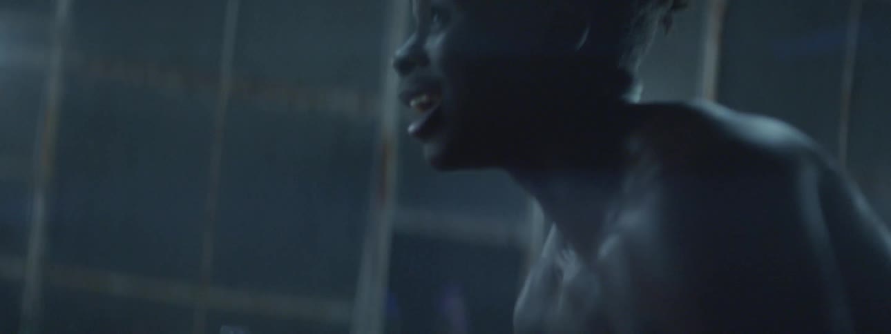 A man dribbles a basketball indoors at night