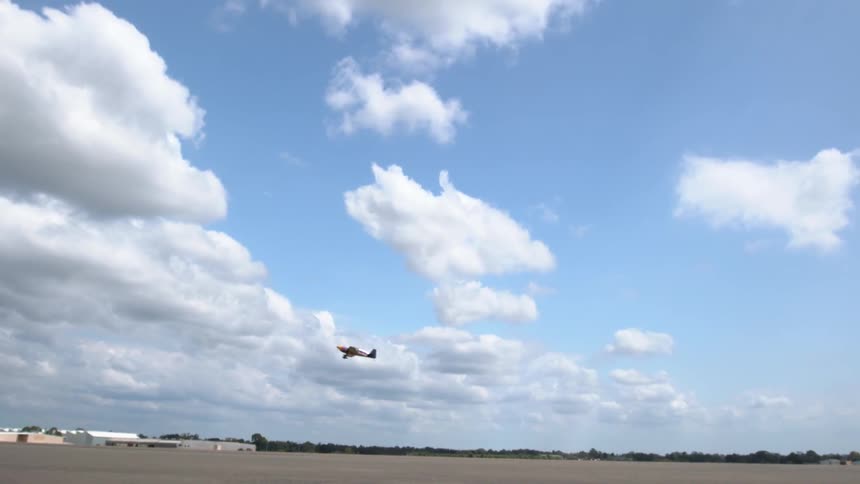 A small plane flies over an airport