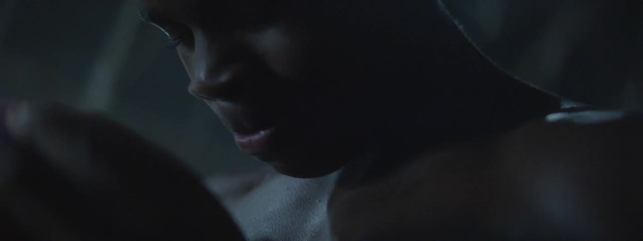 A shirtless man looks down