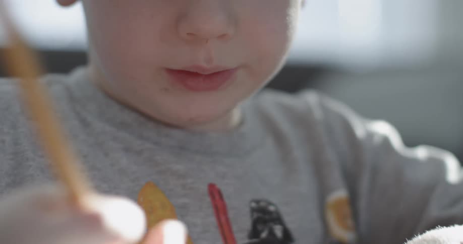 A little boy is using a pencil