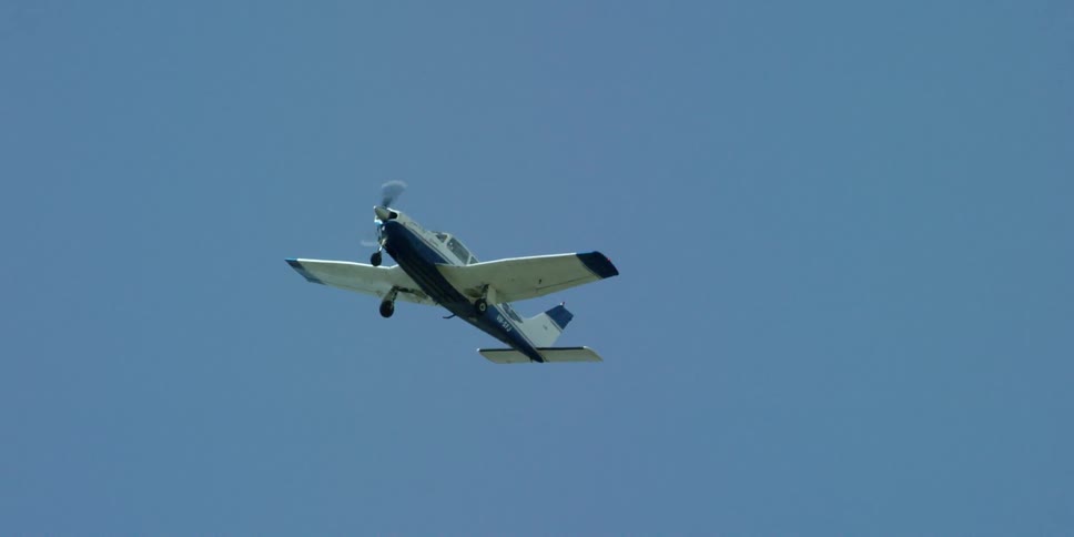 A small airplane flies in the air on a clear day