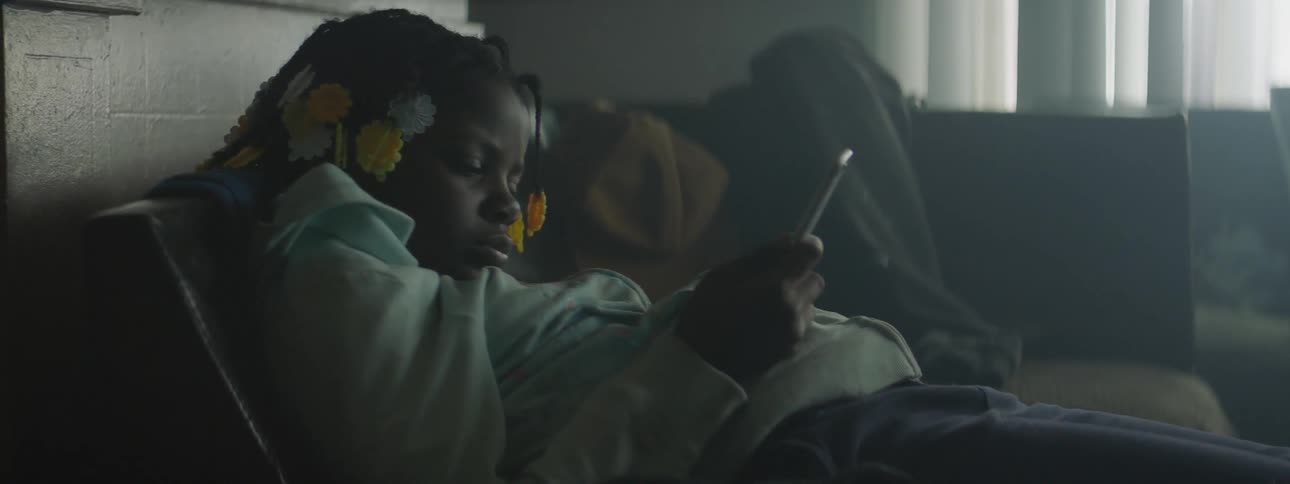 A child looks at a phone why lying down