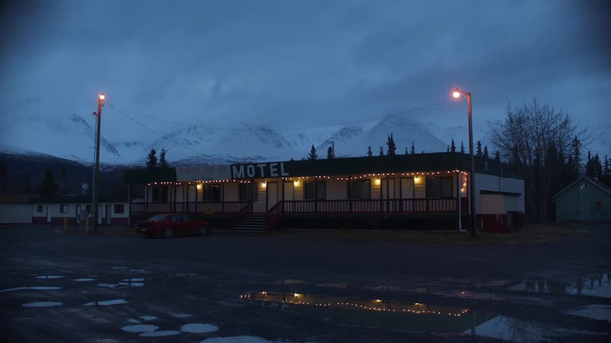 Exterior view of motel with space for parking cars at dusk