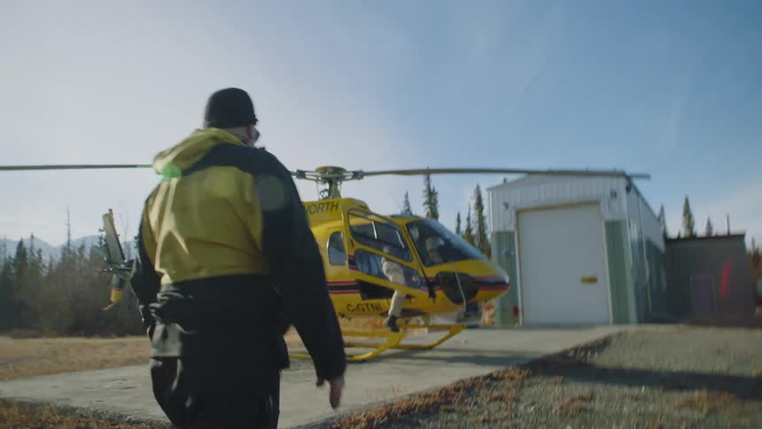 A man gets out of the helicopter and shakes someones hand