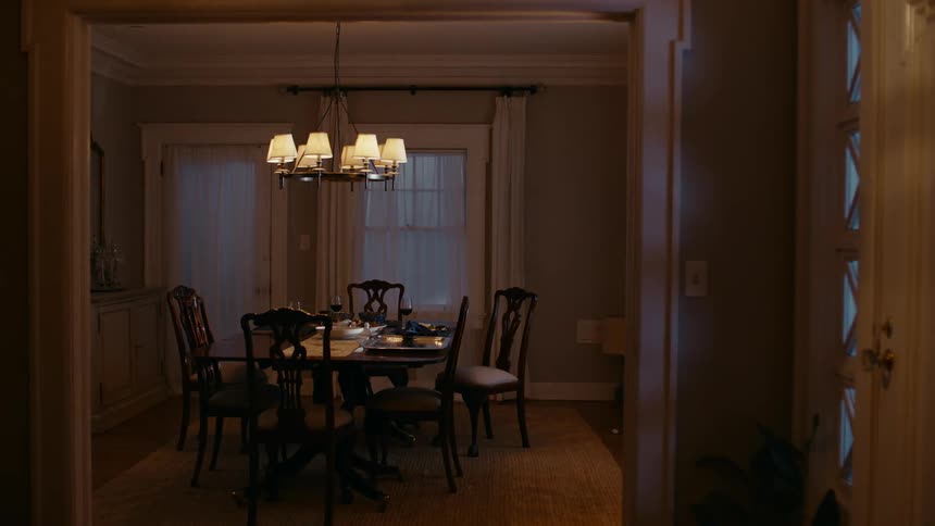 A dining room with a table and chairs and a chandelier over the table