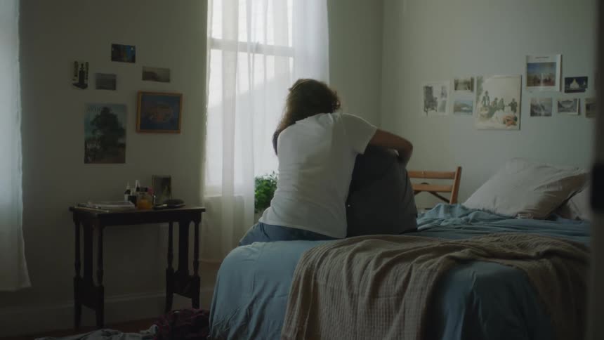 Woman sits on the bed hugging and consoling his boyfriend