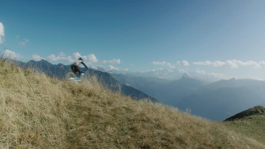 A person is riding their dirt bike through a mountainous landscape