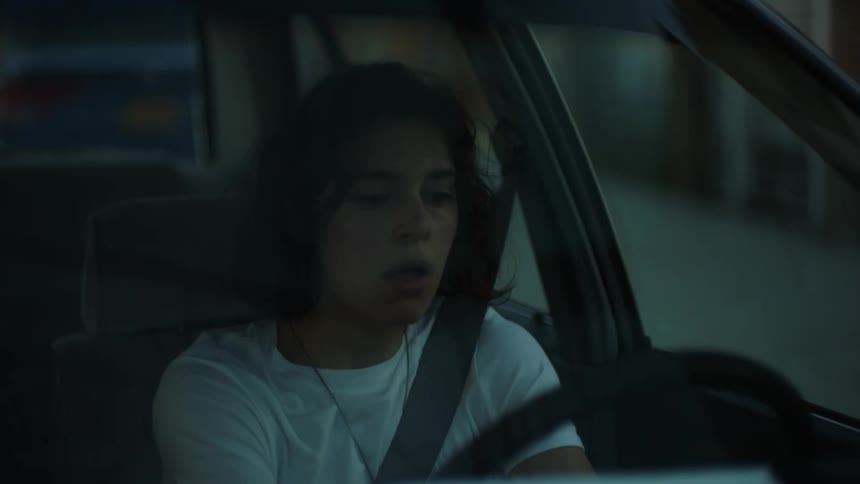 Young woman singing while driving stops and parks after getting suddenly scared
