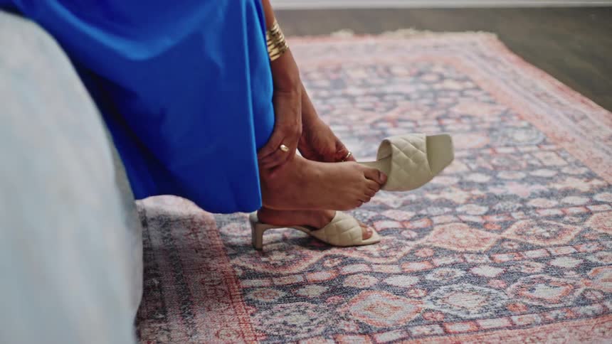 A woman puts on high heels