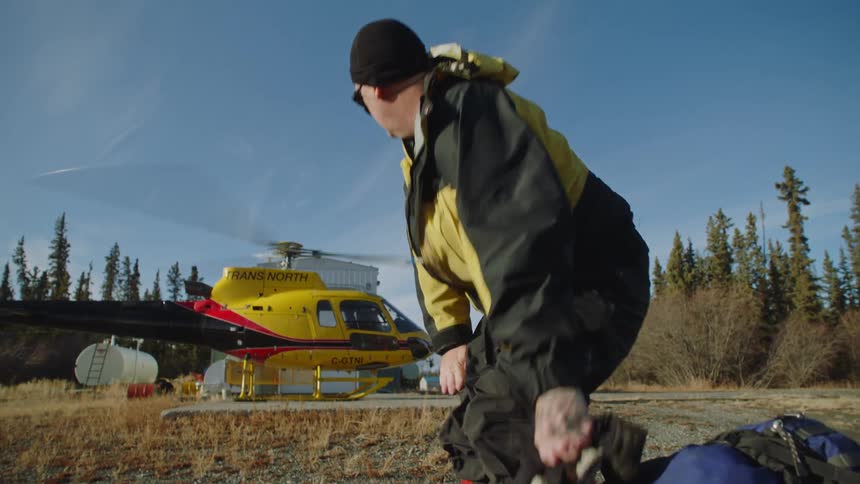 A man gets up by the helicopter