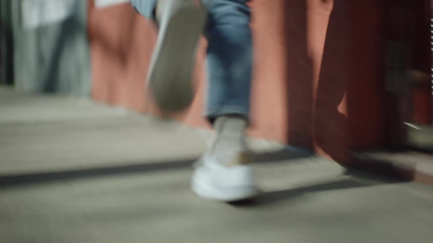 A persons feet as they run down a sidewalk