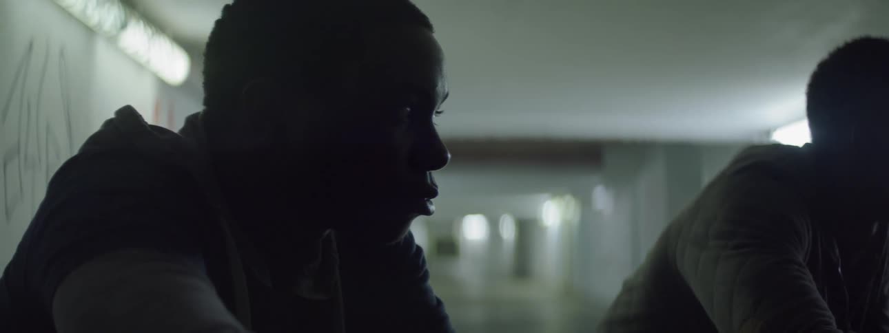 A man stares at an object in the middle of a hallway